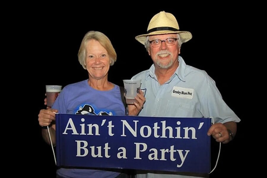 Pam and Al Bricker, founders of Greeley Blues Jam, holding an Ain't Nothin' But a Party banner